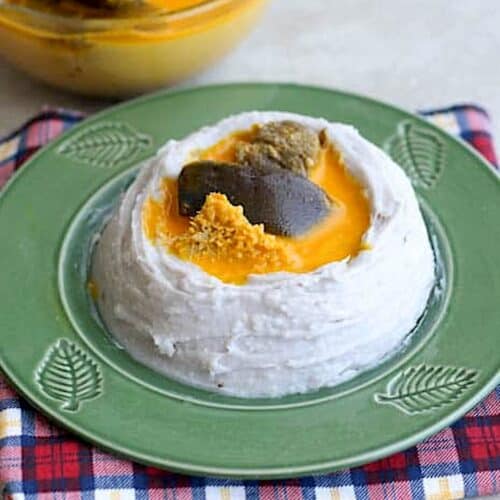 Serving up a bowl of achu soup in a mound of mashed taro.