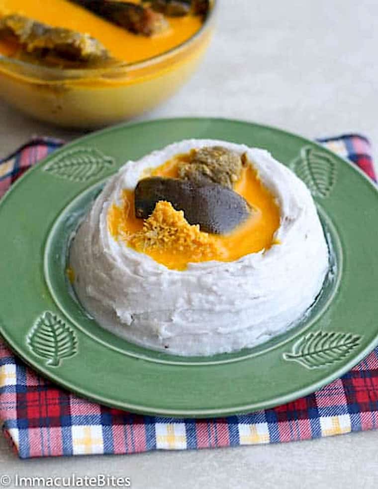 Serving up a bowl of achu soup in a mound of mashed taro.