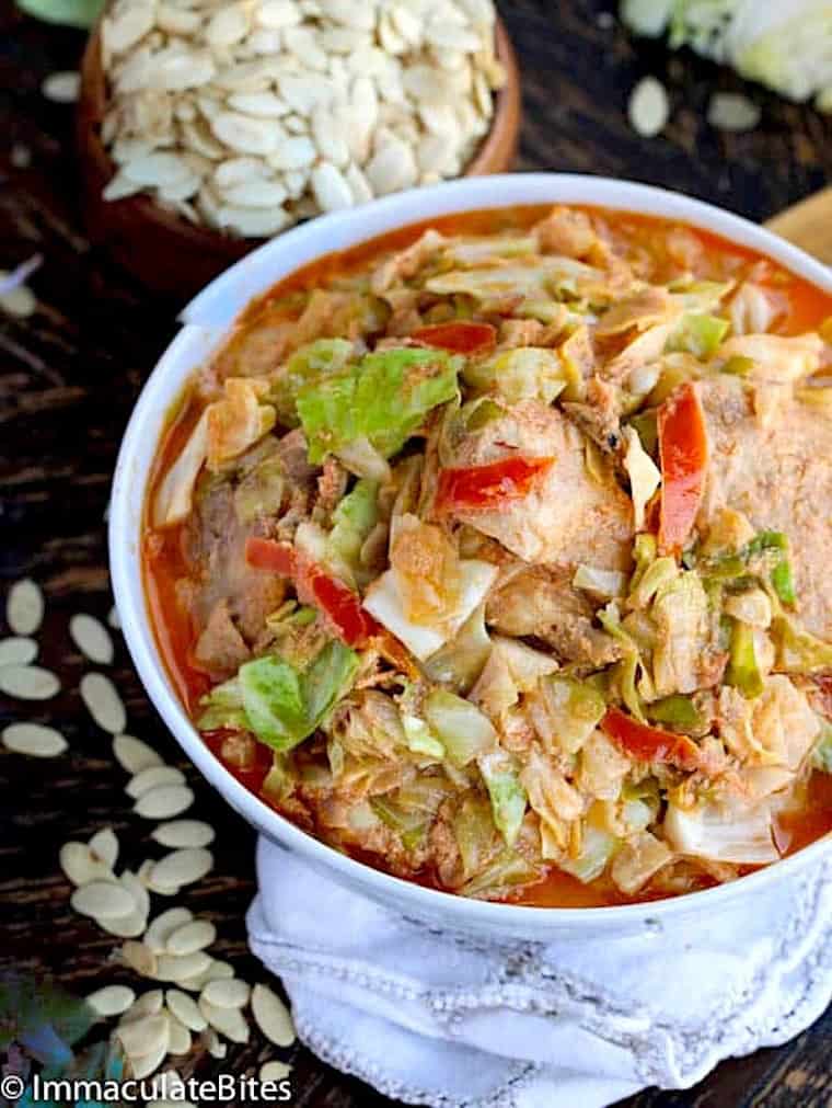 Serving up an insanely delicious bowl of cabbage egusi soup with white melon seeds in the background.