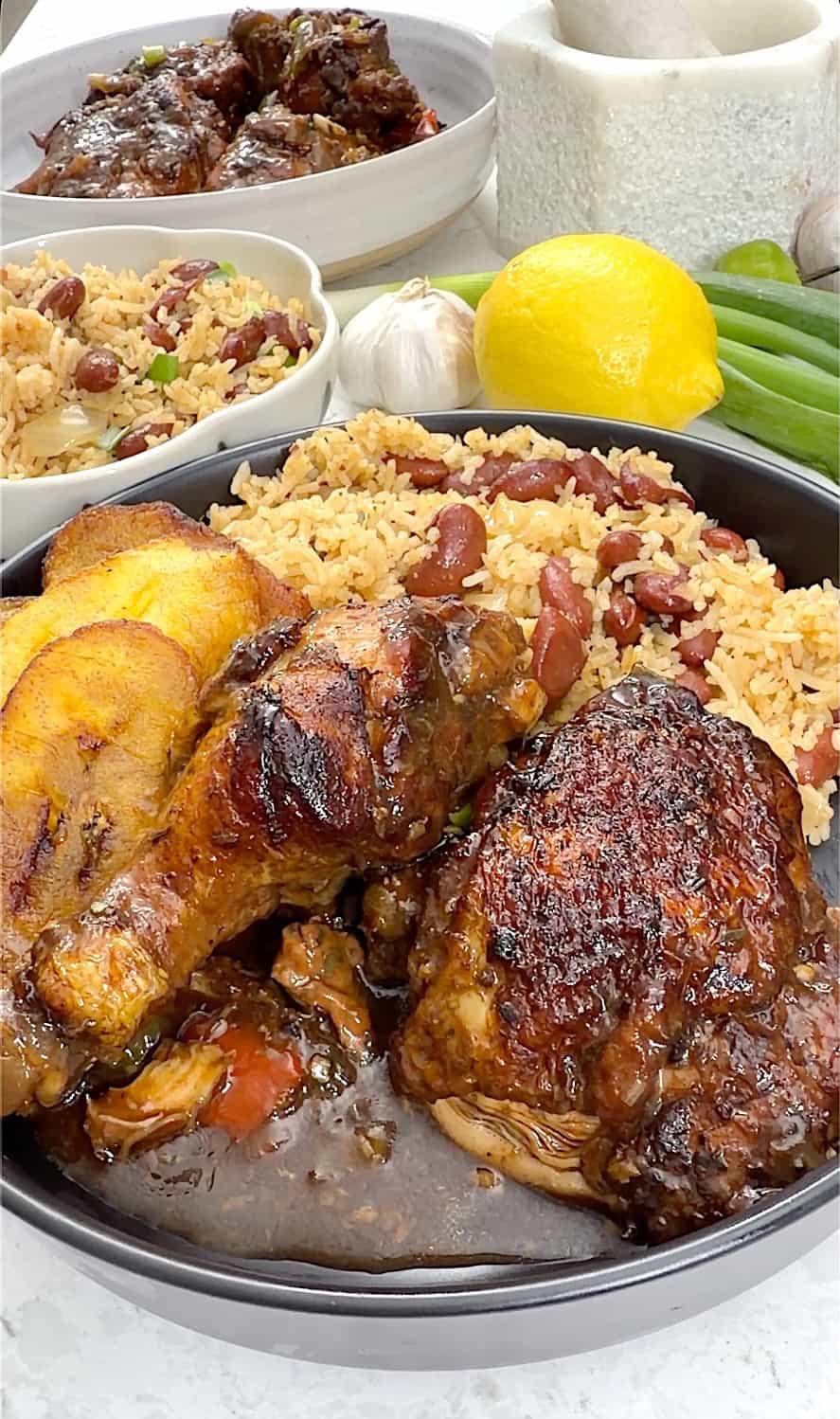 Serving tasty Jamaican chicken stew with Caribbean rice and beans and fried plantains.