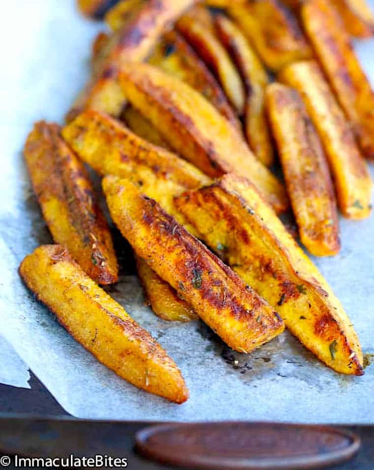Pulling roasted plantains with jerk seasoning from the oven.