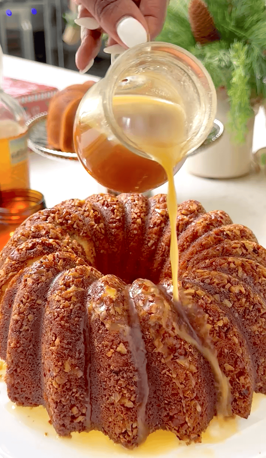 Drizzling the finished cake with rum sauce.