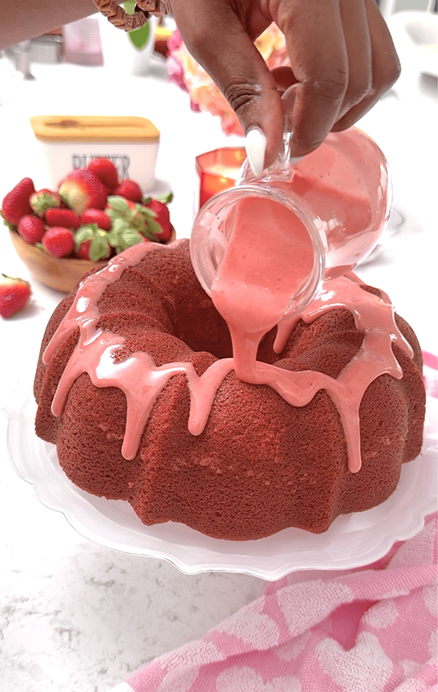 Drizzling a freshly baked cake with strawberry glaze.