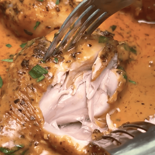 Forking into a juicy, tender chicken leg baked in a decadent cream sauce.