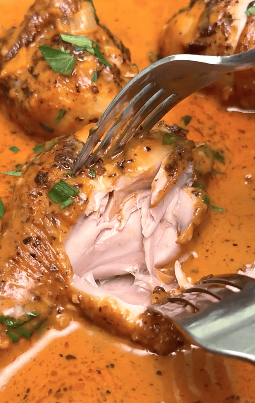 Forking into a juicy, tender chicken leg baked in a decadent cream sauce.