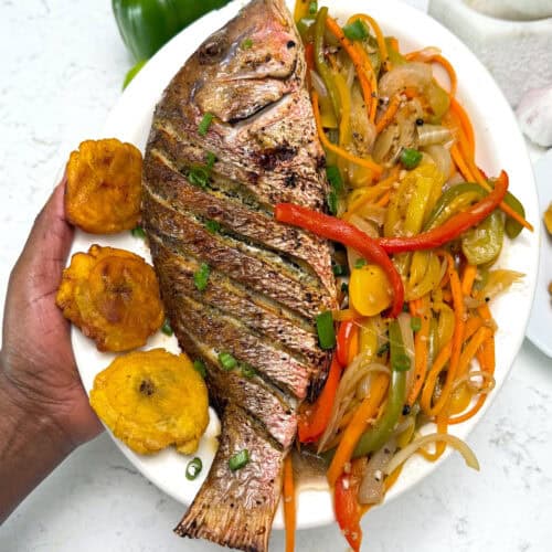 Fried red fish with tostones and sauteed vegetables in a vinegar sauce.