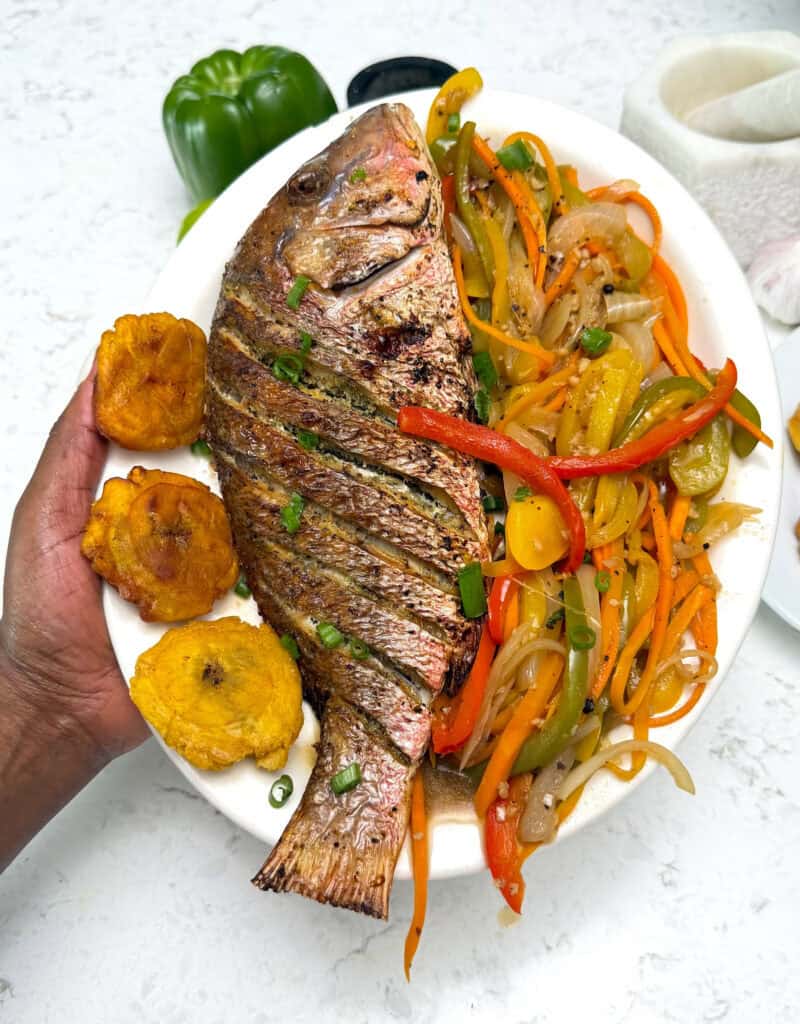 Fried red fish with tostones and sauteed vegetables in a vinegar sauce.