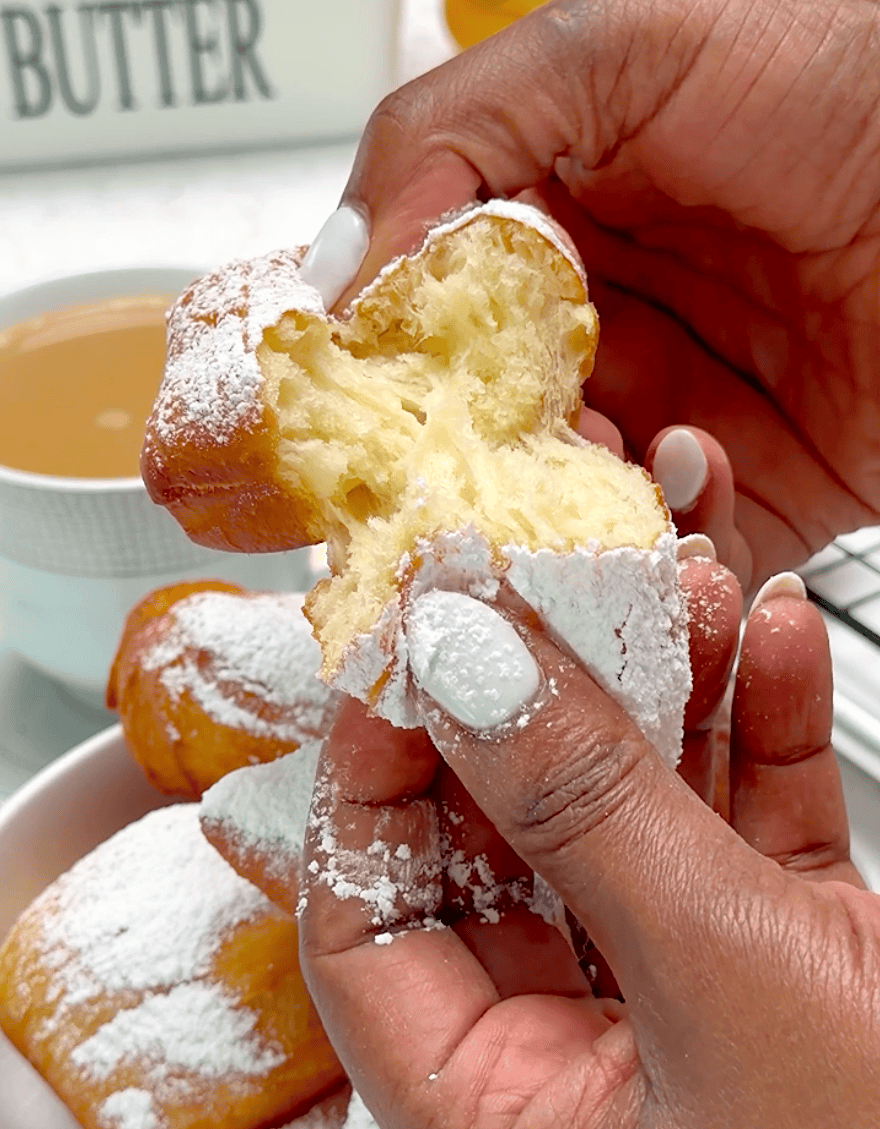 Tearing into a fresh beignet, New Orleans style.