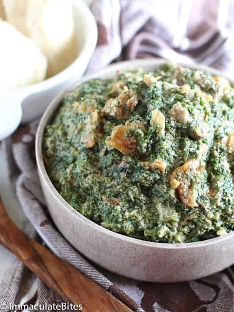 A bowl of freshly cooked pumpkin leaves with meat and fish in a groundnut sauce.