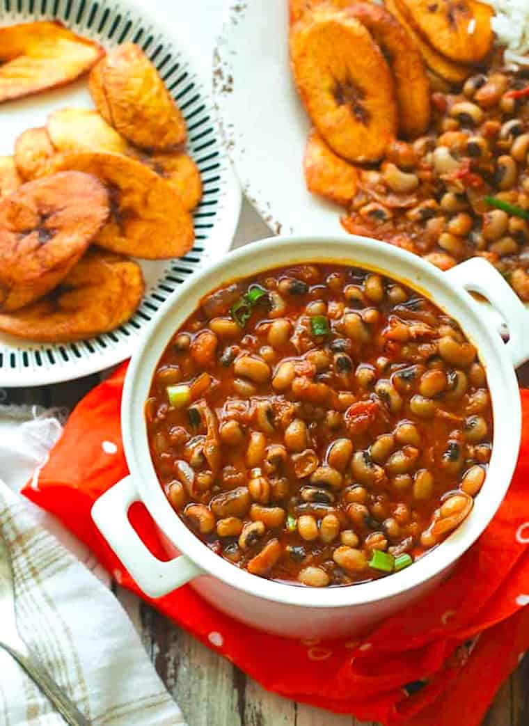 Serving up a pot of red red, African stewed black eyed peas with fried plantains.
