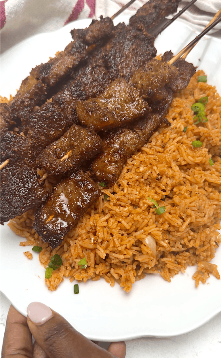 Traditional jollof rice with beef skewers for delicious West African comfort food.