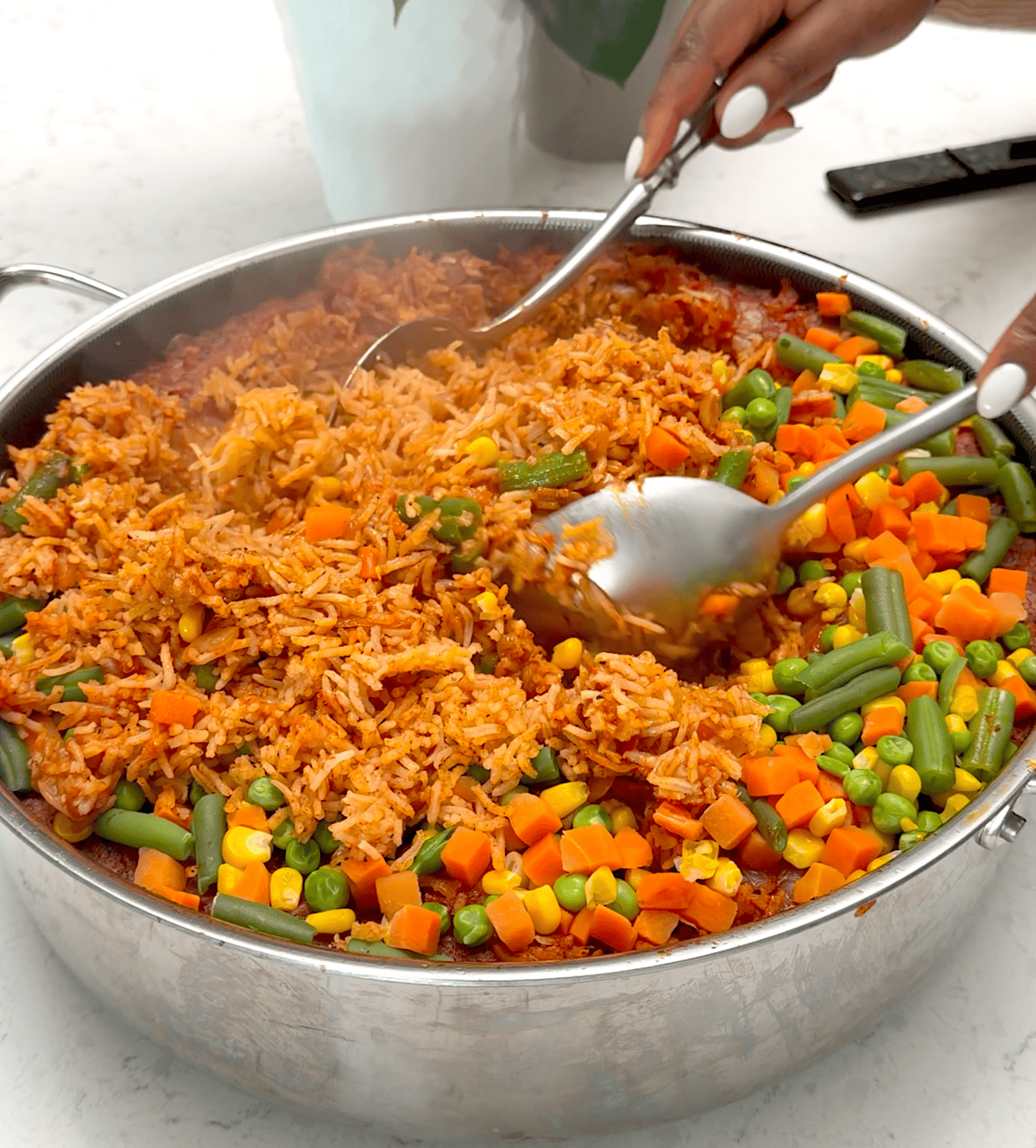 Fluffing freshly cooked rice done jollof style.