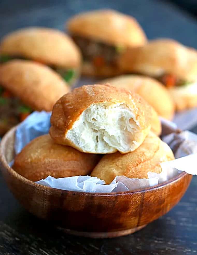 Breaking open a freshly fried South African sandwich bun.
