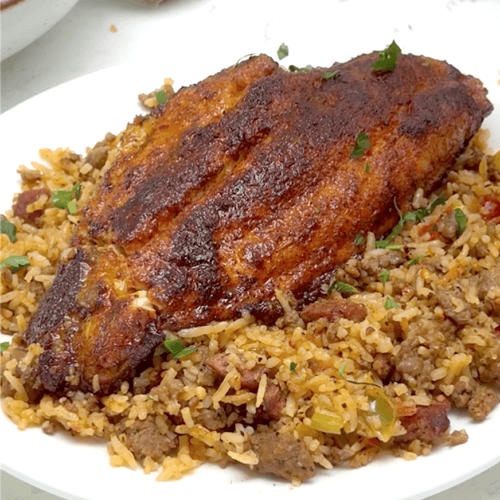 Blackened catfish on a plateful of dirty rice for delicious comfort food.