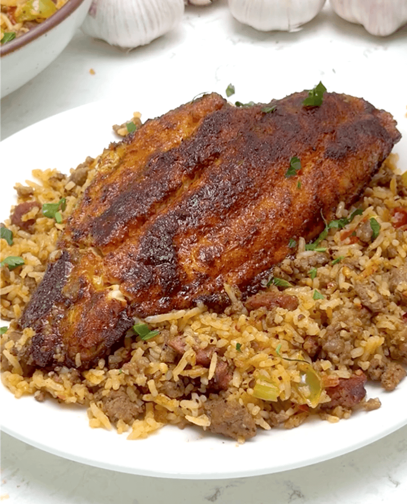 Blackened catfish on a plateful of dirty rice for delicious comfort food.