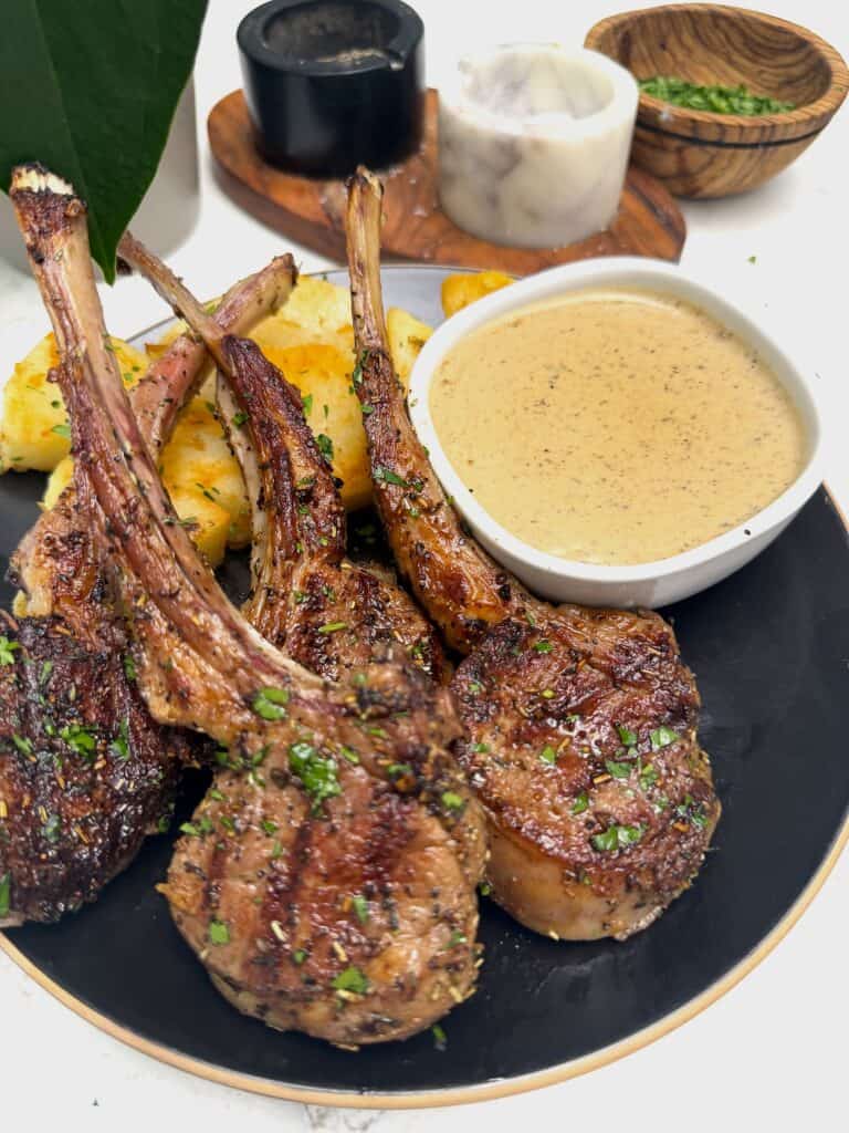 Grilled lamb chops with roasted potatoes and peppercorn sauce for an elegant dinner.