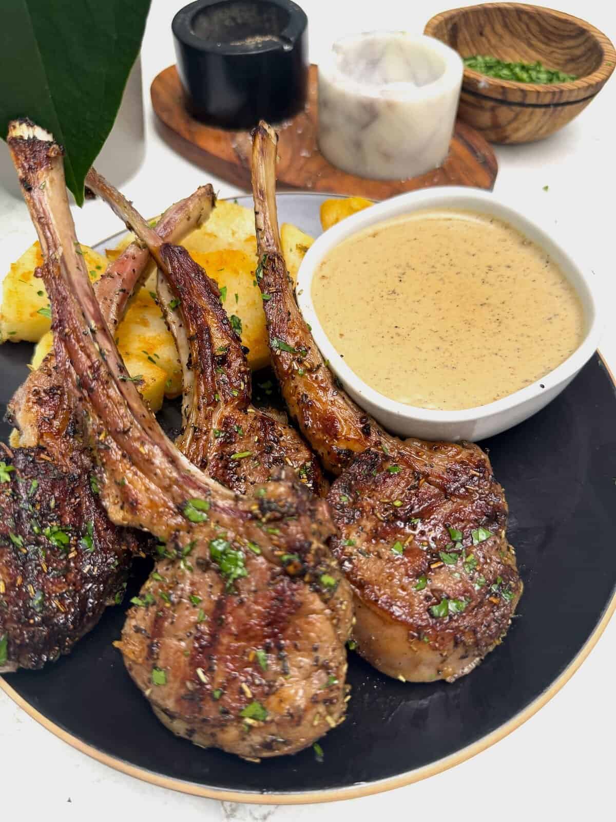 Grilled lamb chops with roasted potatoes and peppercorn sauce for an elegant dinner.