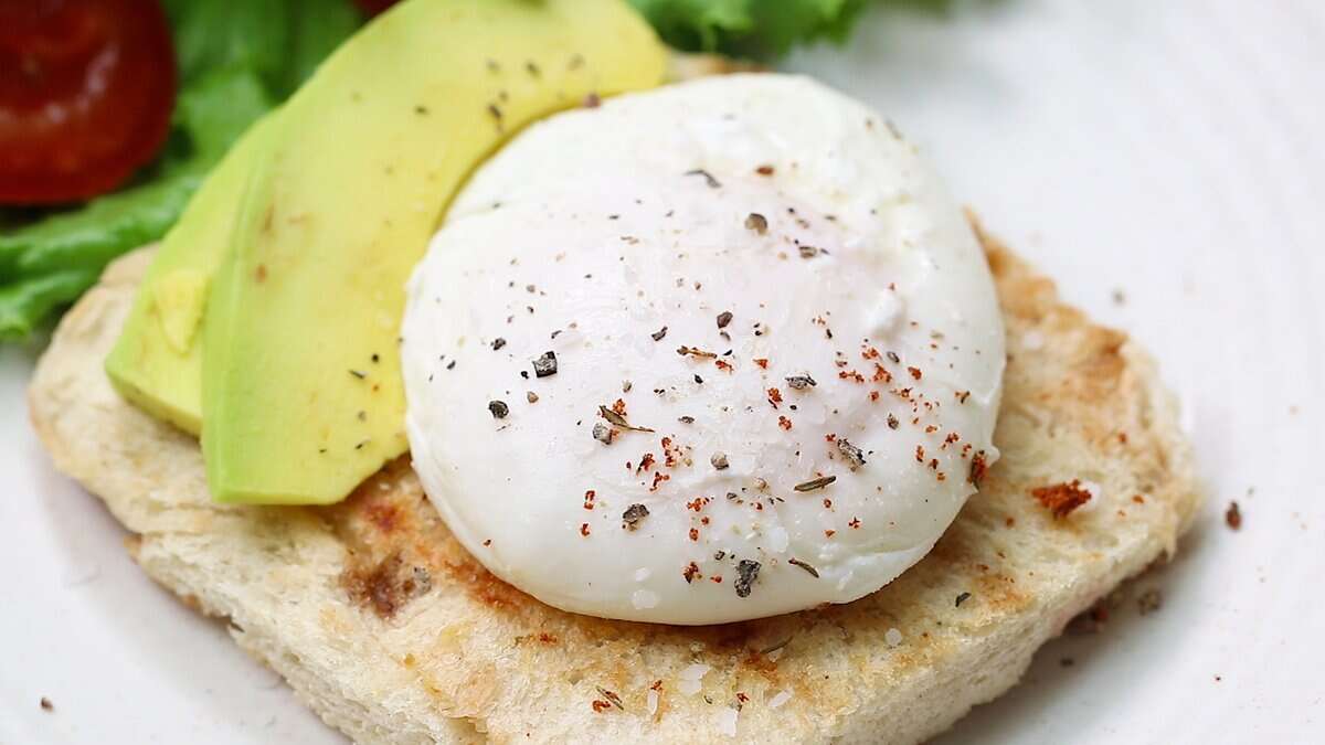 Enjoying a poached egg on toast with avocado.