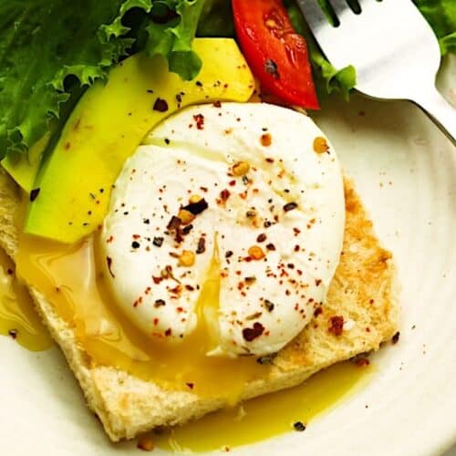 A perfectly runny yolk of a poached egg tops avocado toast and a refreshing salad.