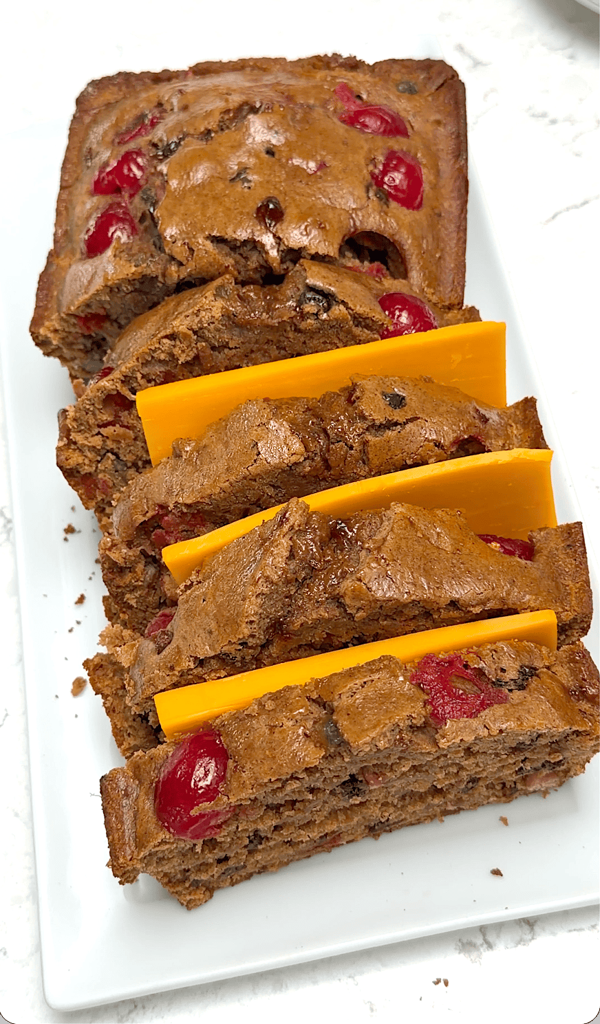 Serving a Jamaican spice bun with slices of sharp cheddar cheese for Easter.