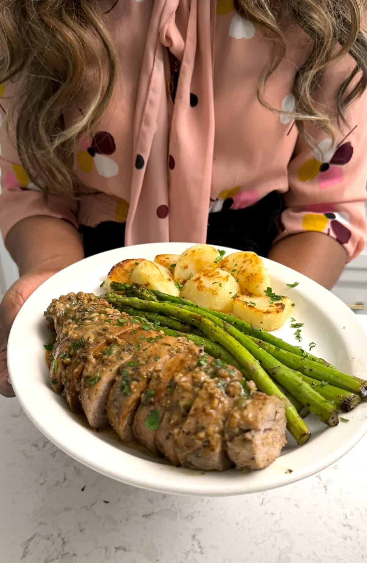 Imma serving up marinated pork tenderloin roast with asparagus and potatoes fresh from the oven.