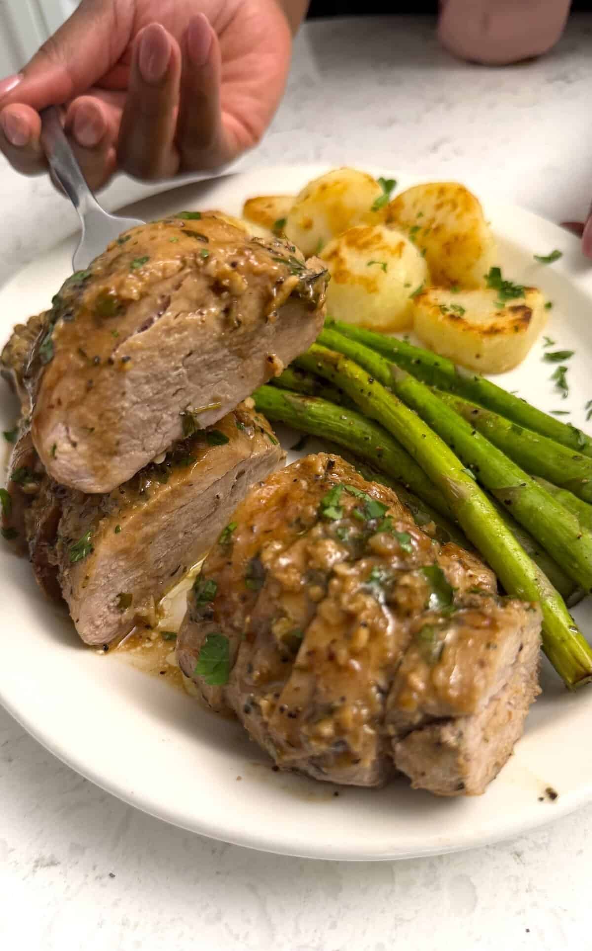 Grabbing a slice of roasted pork drizzled with the sauce.