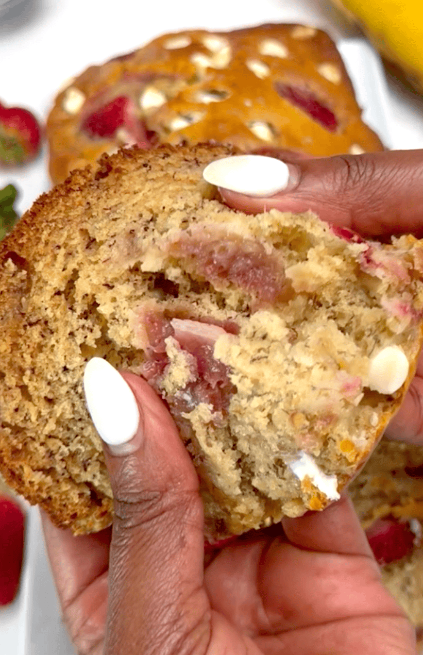 Breaking into a warm, decadent slice of banana bread with strawberries and white chocolate.