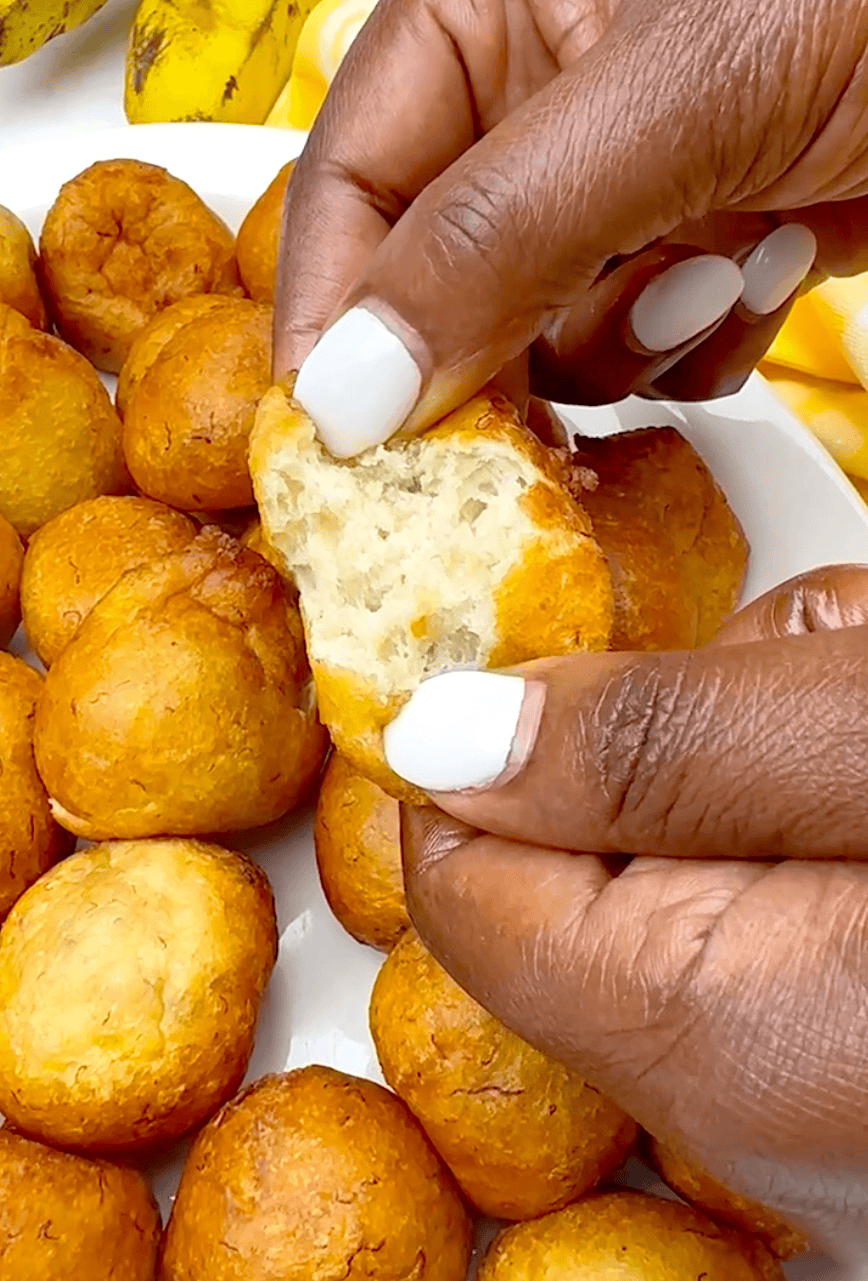 Breaking into a freshly fried and steaming hot puff puff made with mashed bananas.