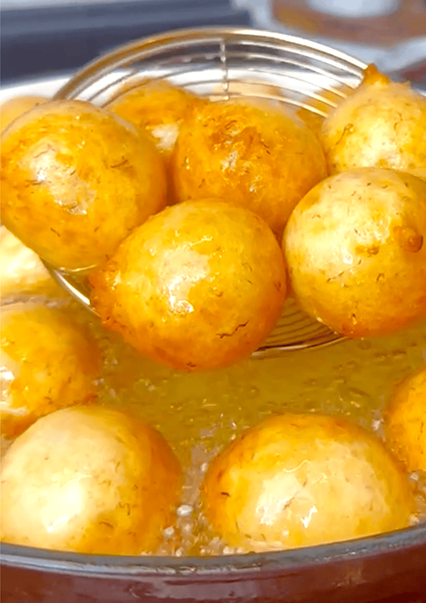 Golden banana puff puff coming out of the hot oil and ready to serve.