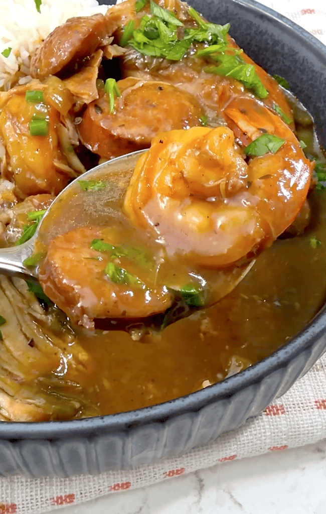 Enjoying a traditional gumbo recipe with shrimp, chicken, and andouille sausage.