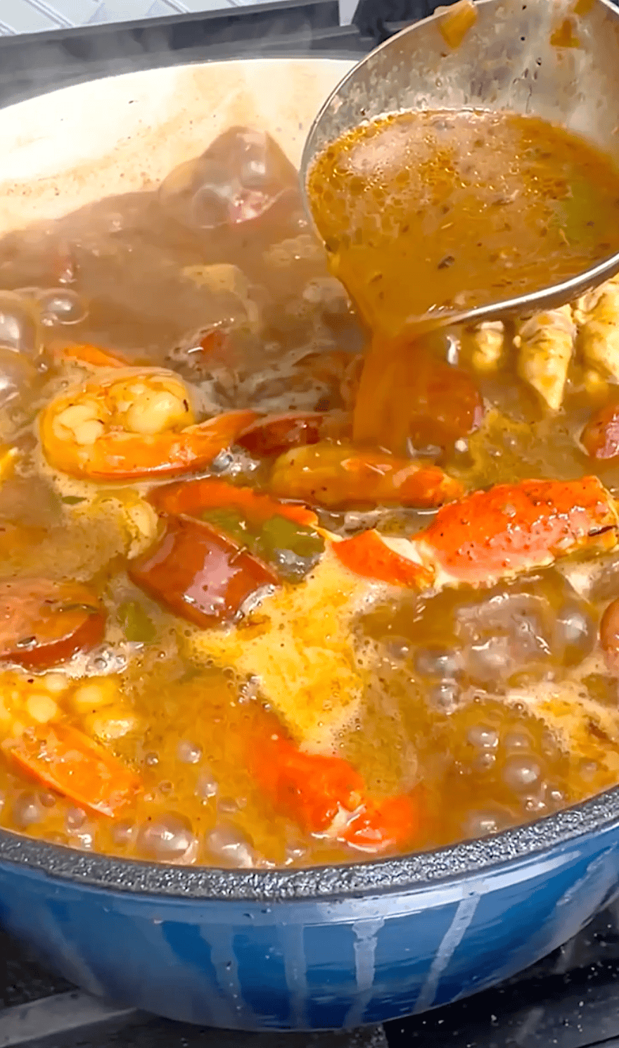 Ladling up freshly made gumbo for a traditional Creole or Cajun dinner.