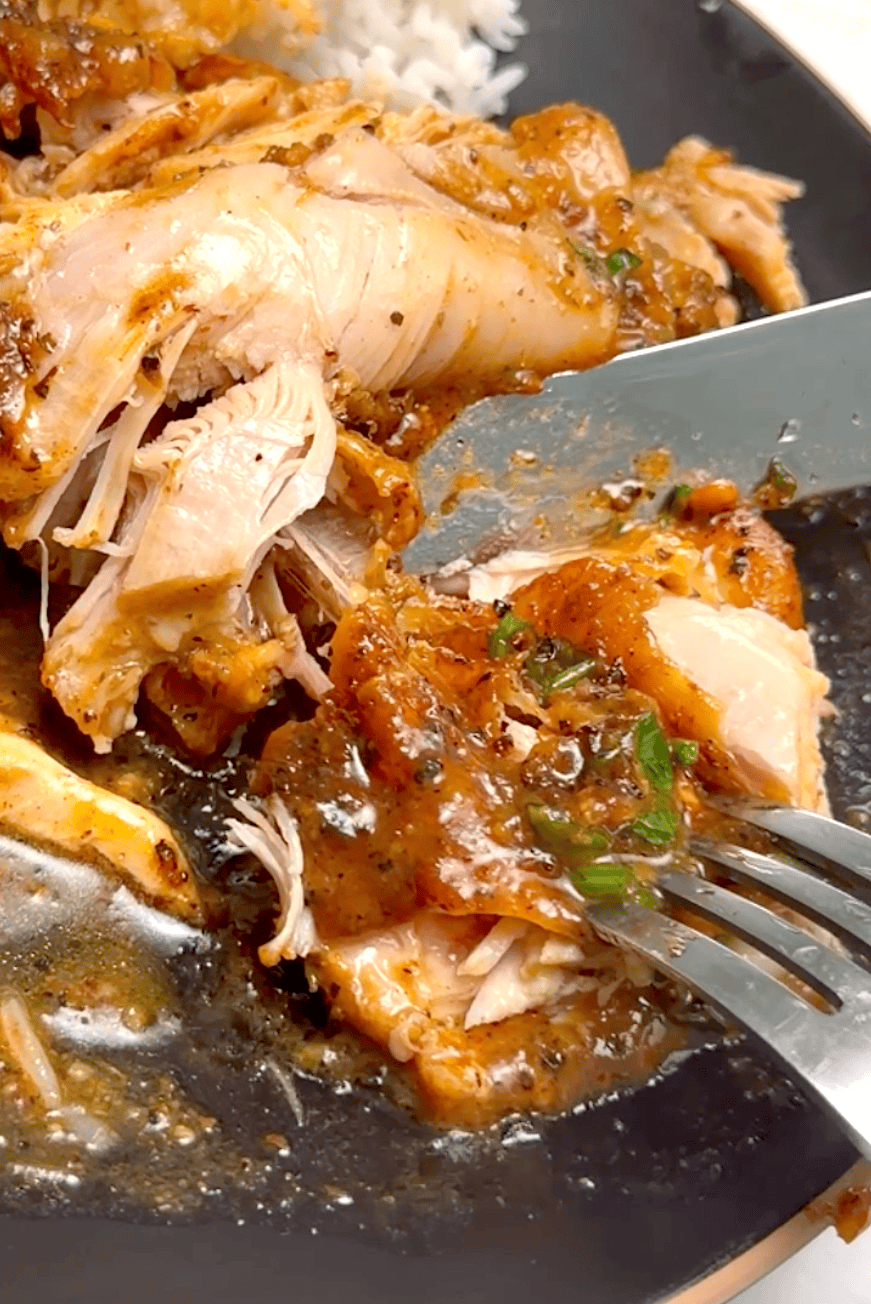 Forking into a fall-off-the-bone tender chicken thigh simmered in a pineapple garlic sauce.