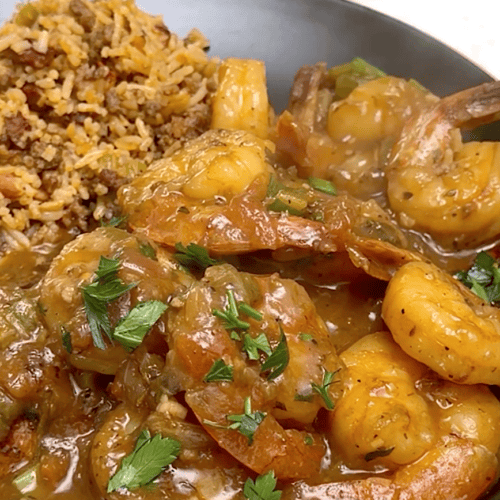 Delivering a plateful of shrimp etouffee with dirty rice for a delicious meal.