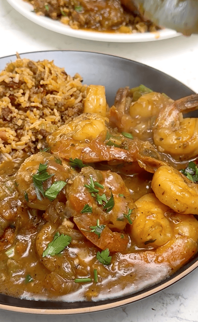 Delivering a plateful of shrimp etouffee with dirty rice for a delicious meal.