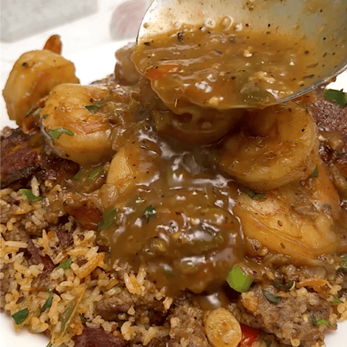 Drizzling thick etouffee sauce over shrimp and rice.