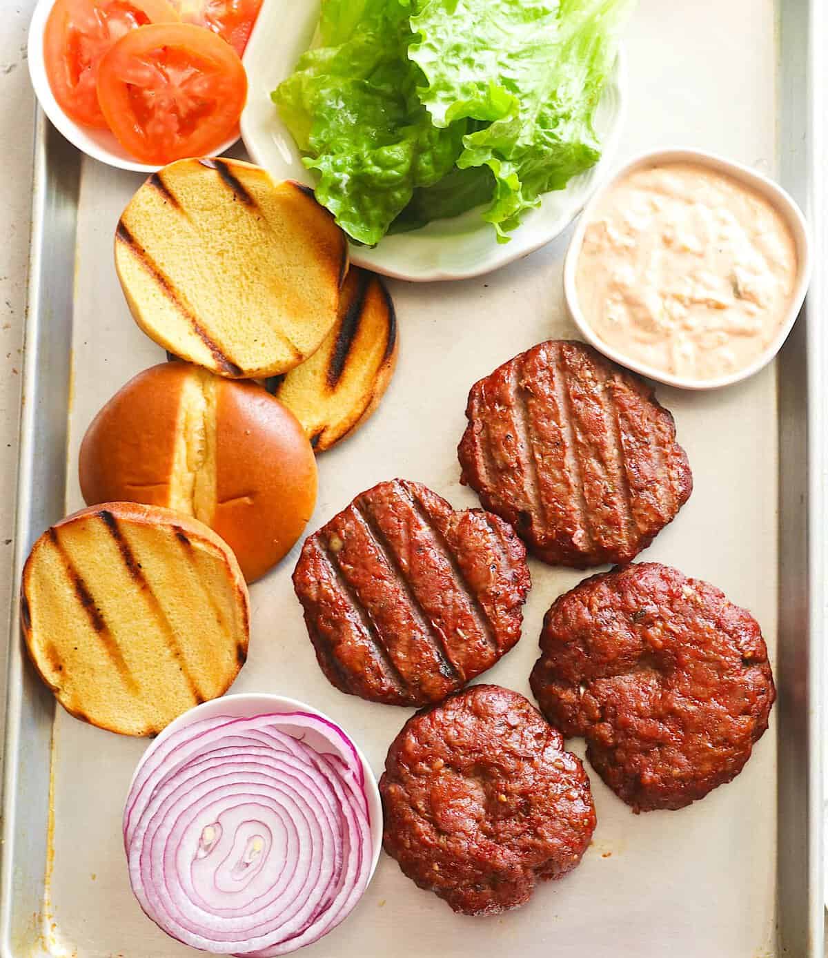 Assembling hamburgers with buns and the desired toppings.