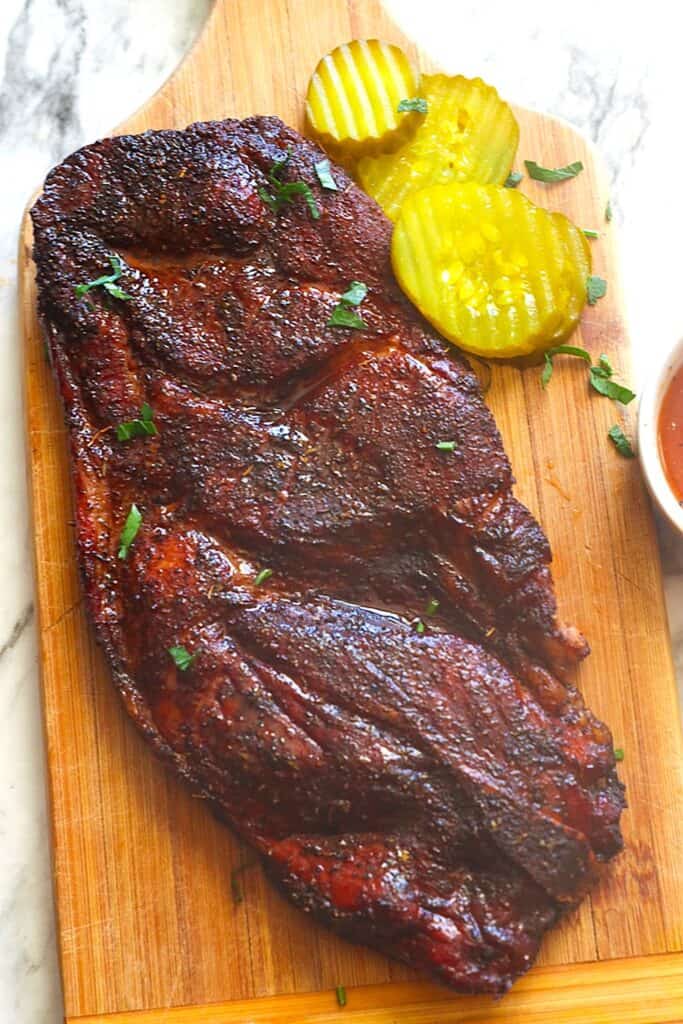 Freshly smoked pork steaks with pickles and hot sauce.