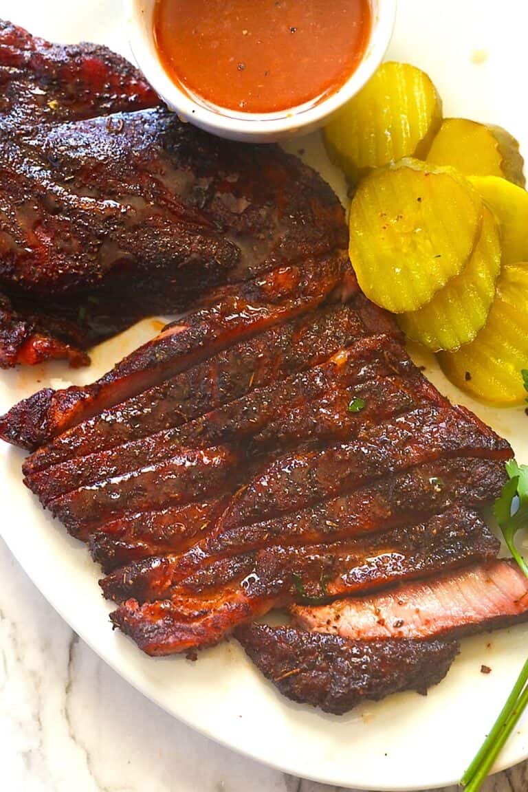 Slicing into a pork steak fresh from the smoker for an economical cookout element.