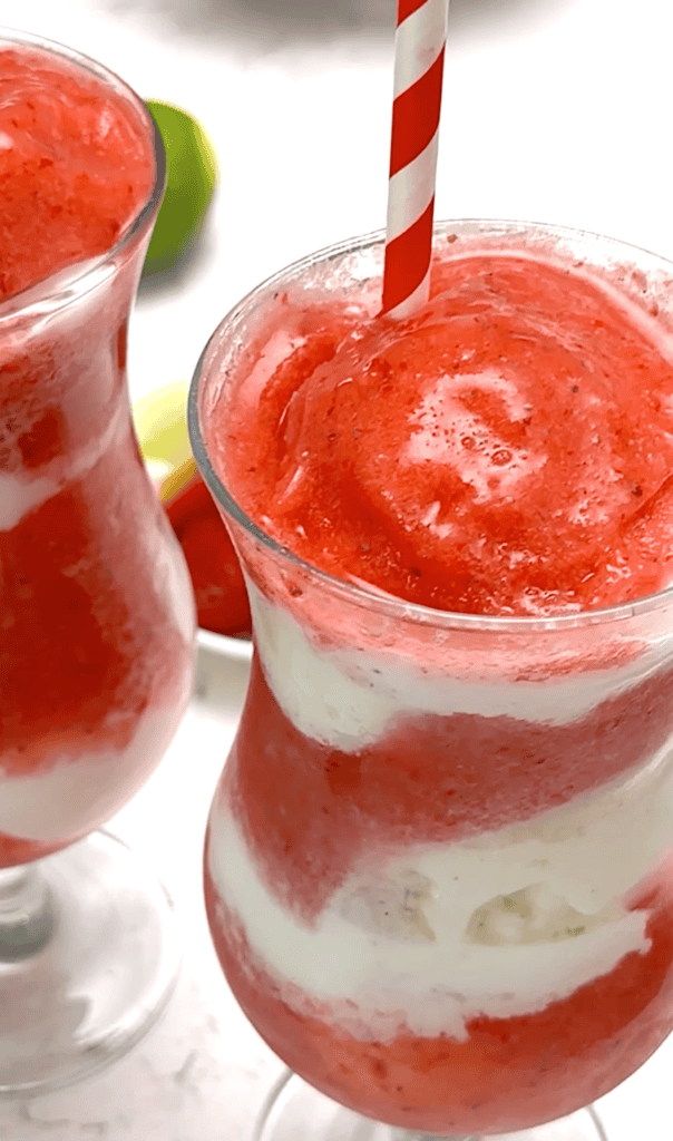 Two daiquiris loaded with strawberries and layered with vanilla ice cream for an exquisite dessert.