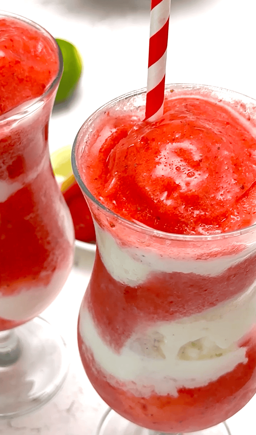 Two daiquiris loaded with strawberries and layered with vanilla ice cream for an exquisite dessert.