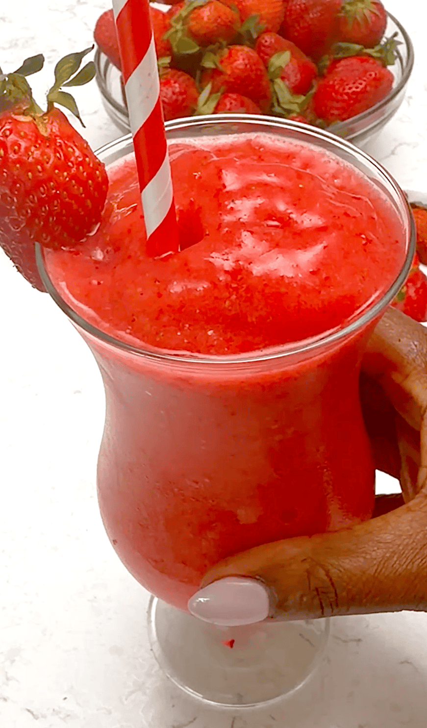 Enjoying a refreshingly cold strawberry daiquiri on a hot summer day.