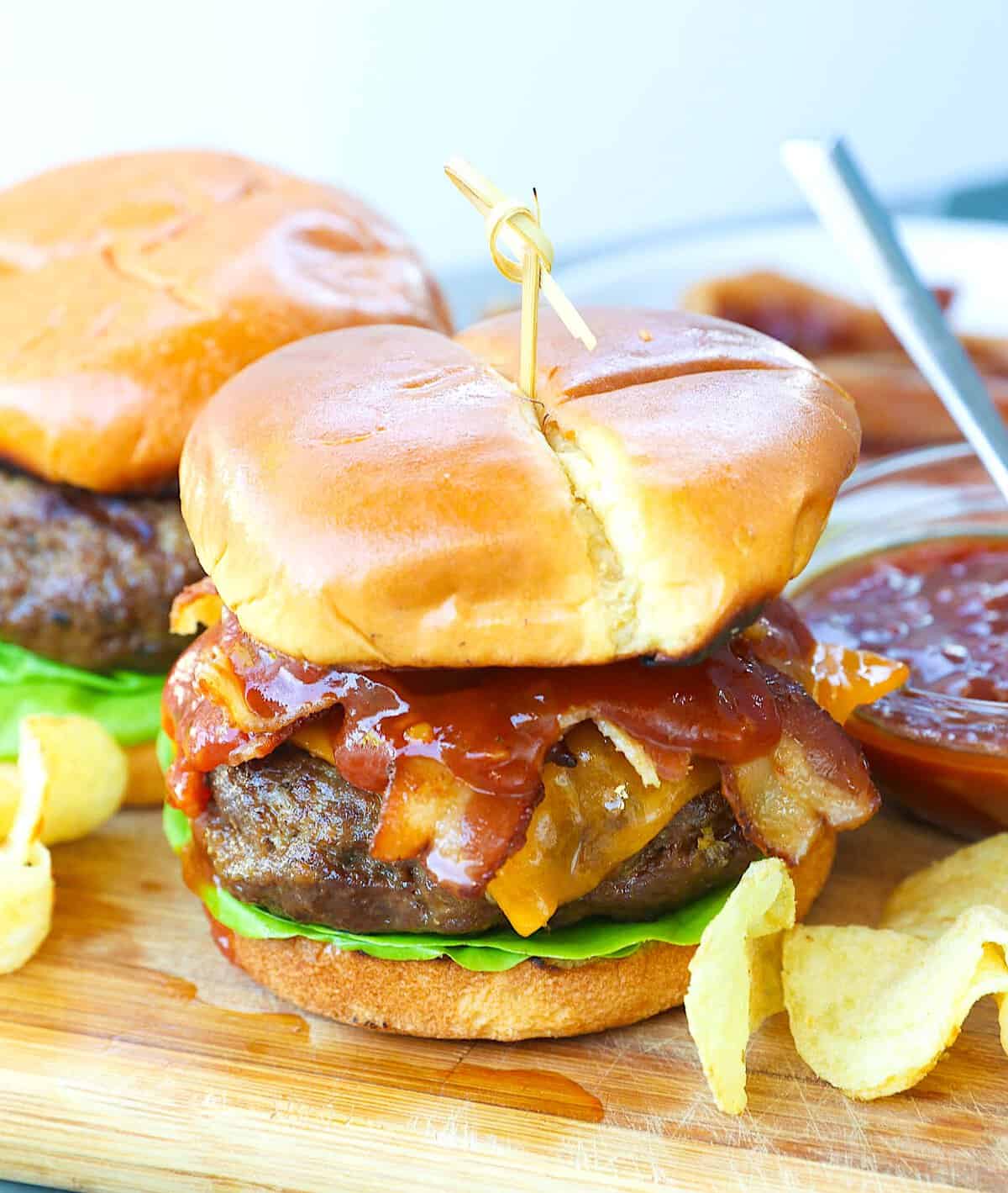 A homemade backyard burger loaded with BBQ sauce and bacon.