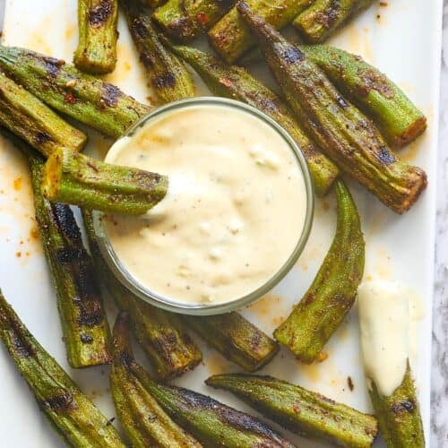 Enjoying a remoulade dipping sauce with grilled okra.