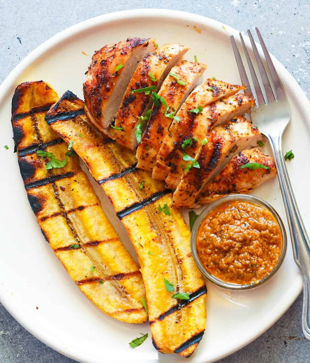Enjoying plantains and chicken from the grill with red pepper sauce.