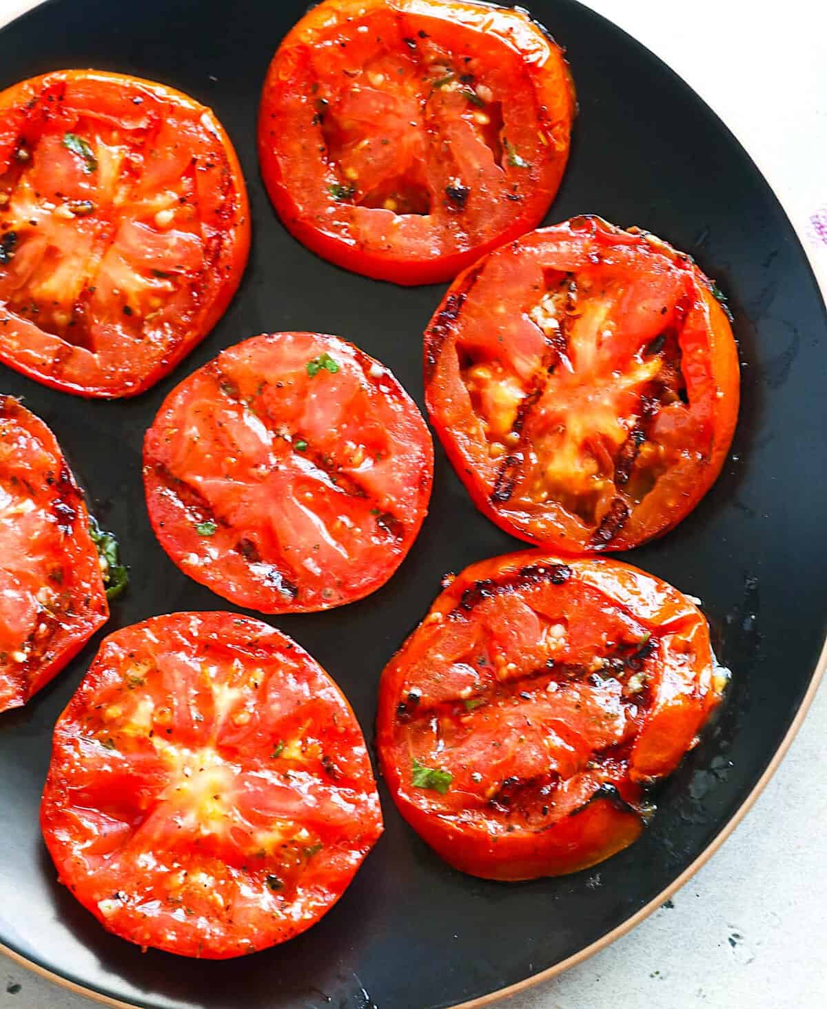 A plate of grilled tomatoes fresh from the fire and ready to enhance your weekend dinner.
