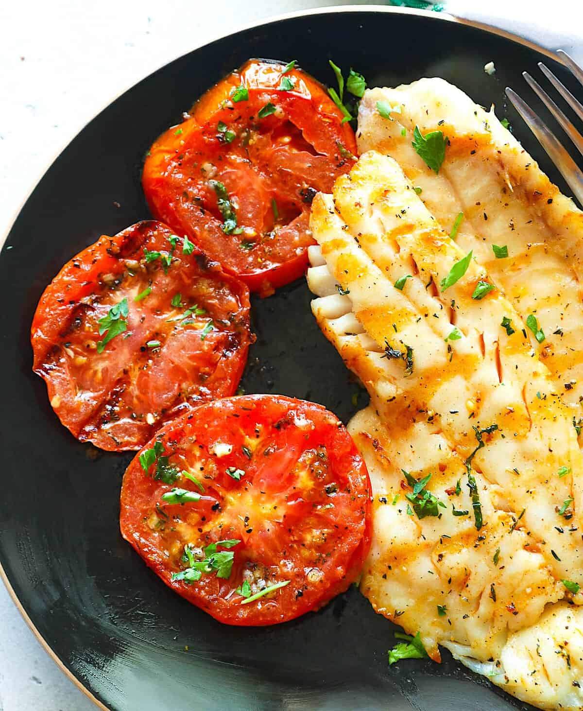 Enjoying pleasantly roasted tomatoes with grilled rockfish.