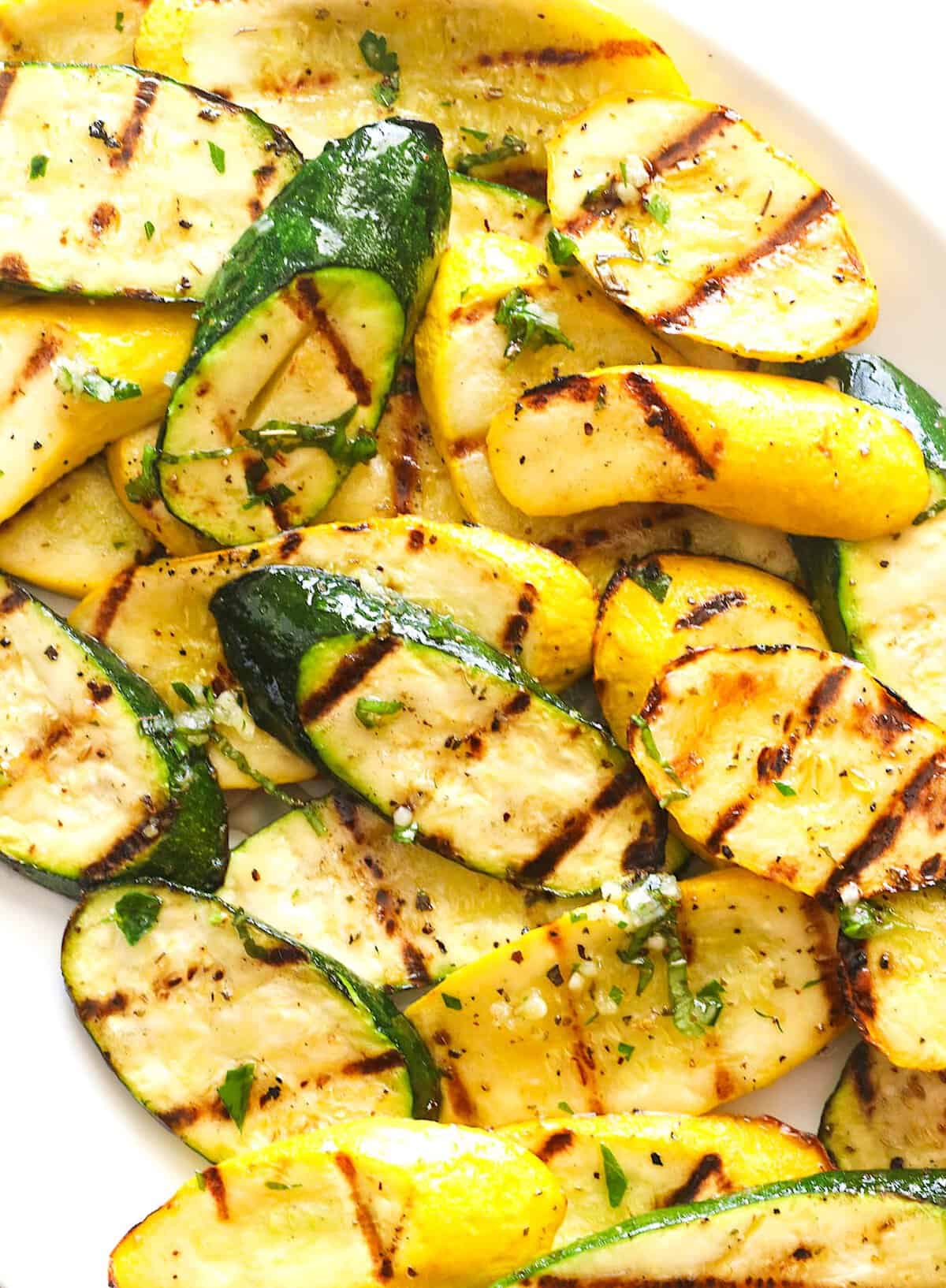 Grilling sliced zucchini and yellow squash.