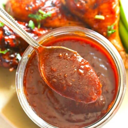 A spicy, smoky bowl of homemade honey BBQ sauce ready to slather smoked chicken legs.