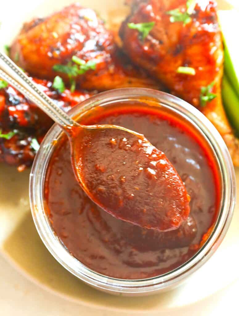 A spicy, smoky bowl of homemade honey BBQ sauce ready to slather smoked chicken legs.