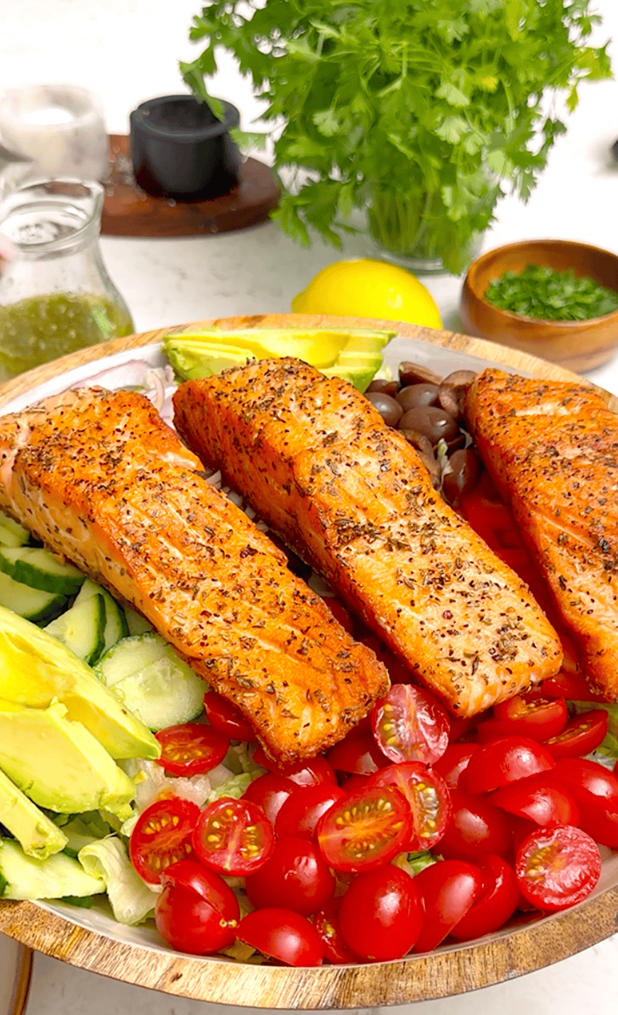A fresh summer salad topped with salmon filets.
